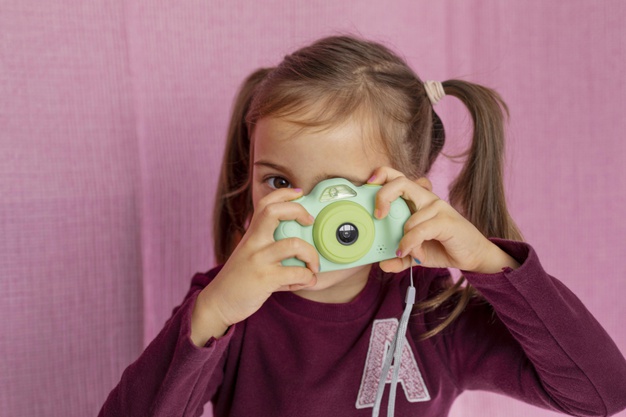 portrait-little-girl-playing-with-camera_23-2148886436